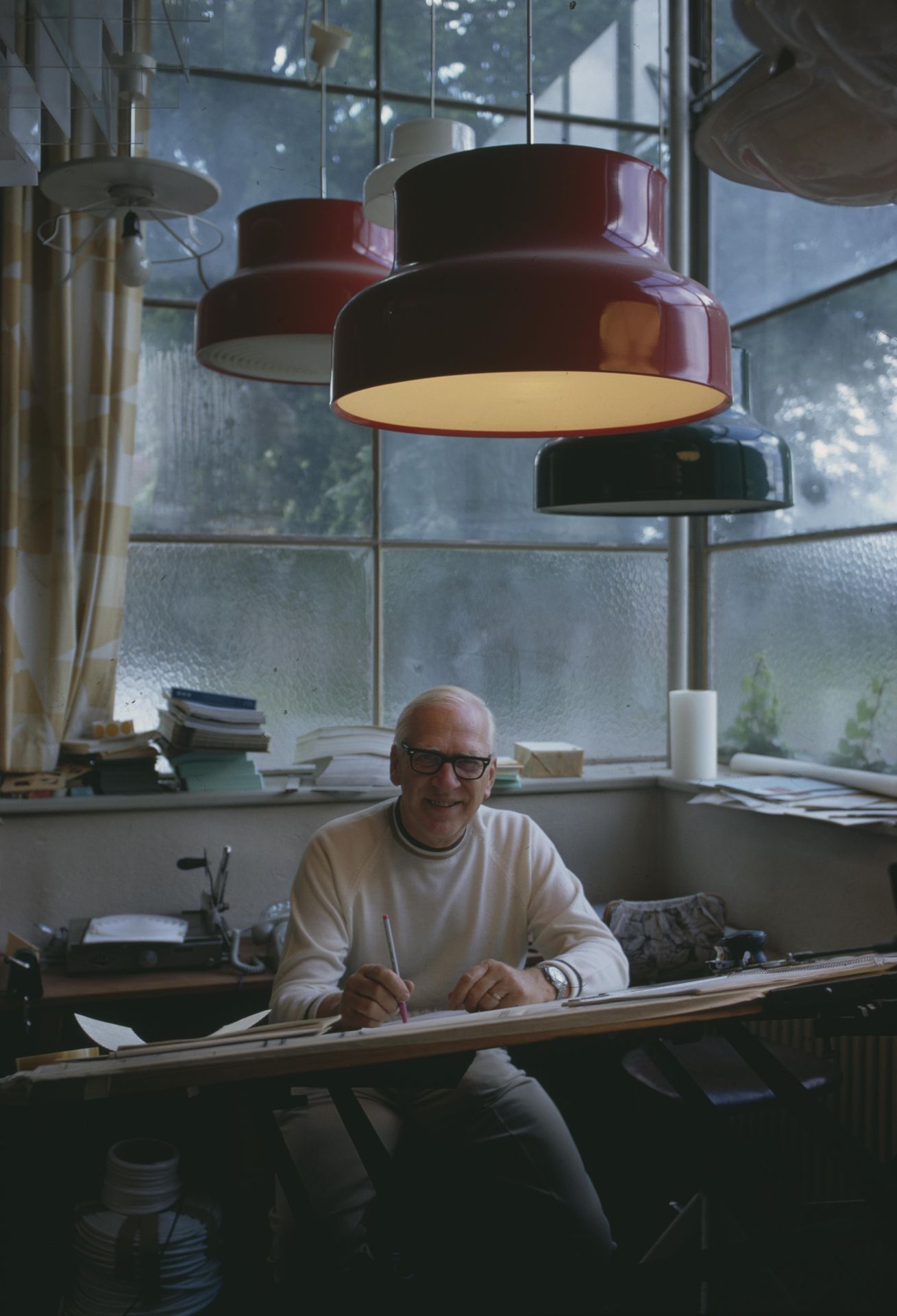Anders Pehrson at his desk under Bumling pendants, 1970